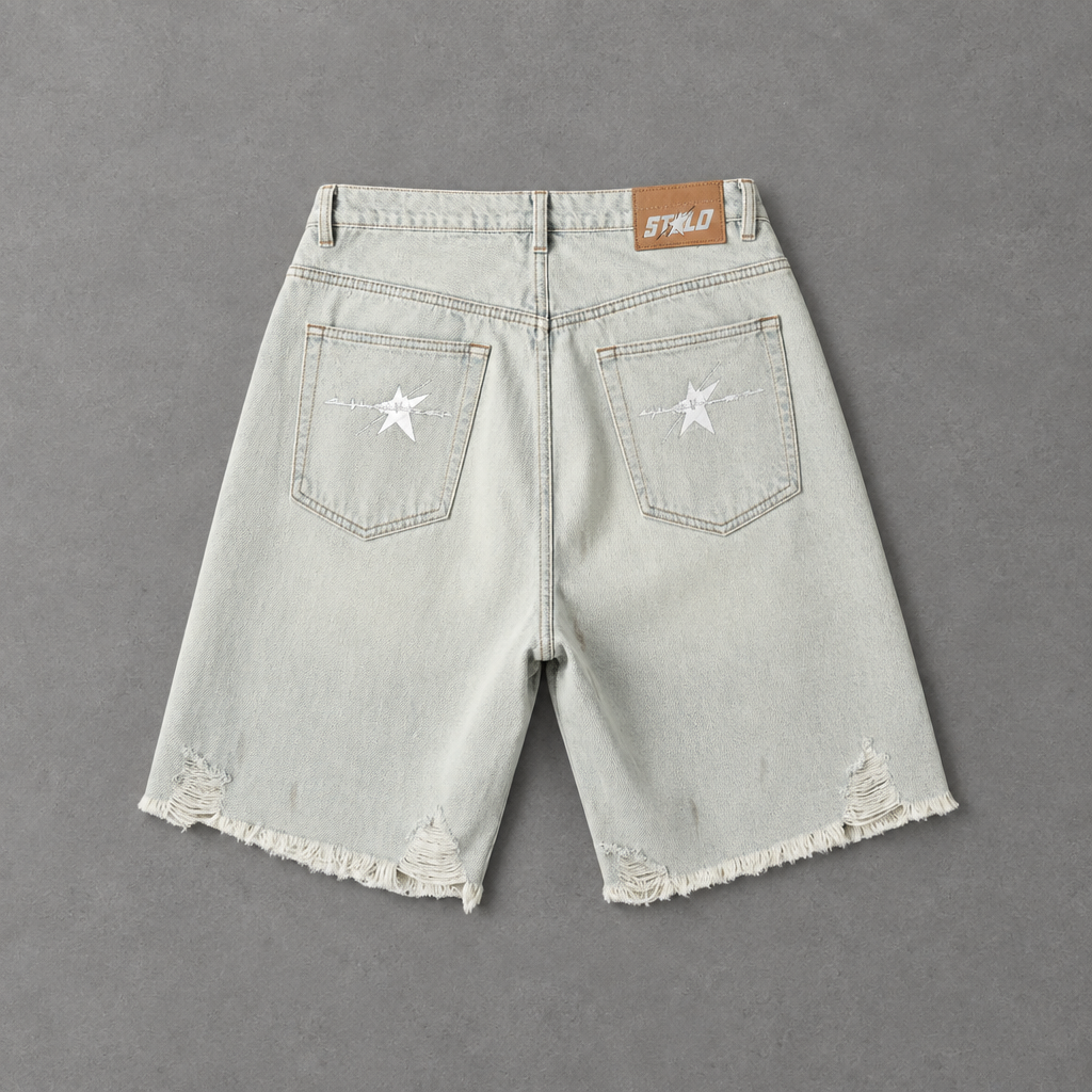 Back of light distressed denim shorts on grey studio floor