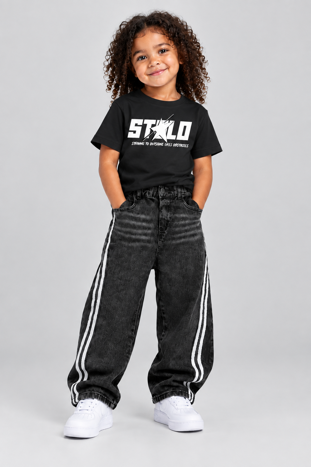 Child model wearing the black STOLD tee and striped jeans, front view