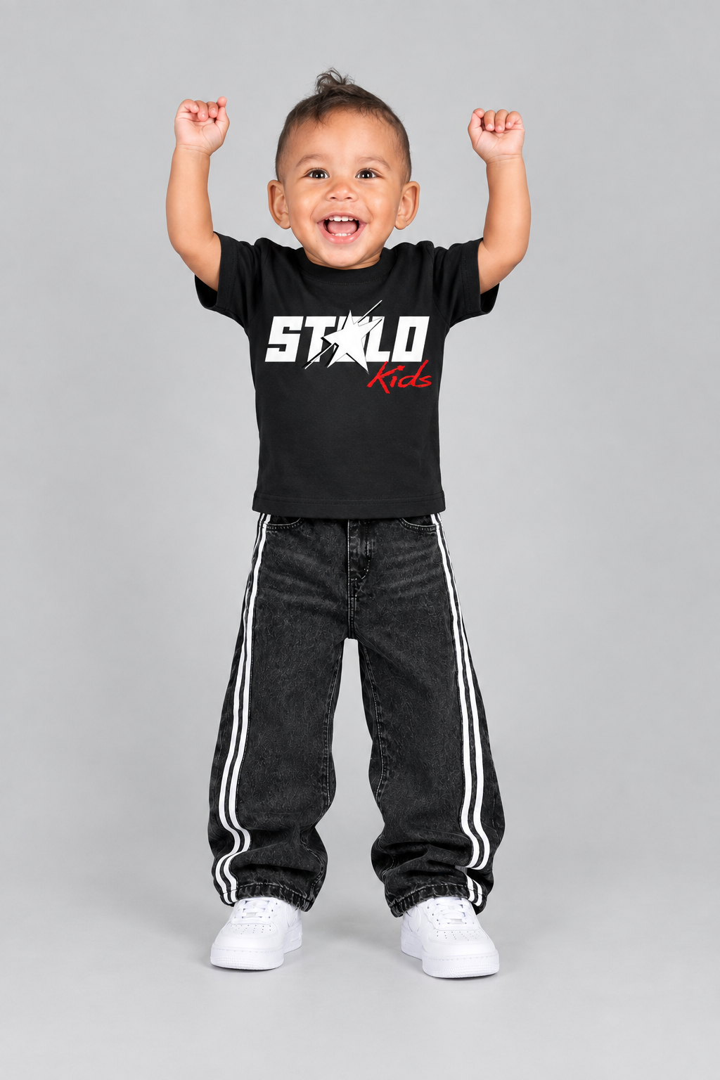 Front view with his arms raised and white sneakers visible