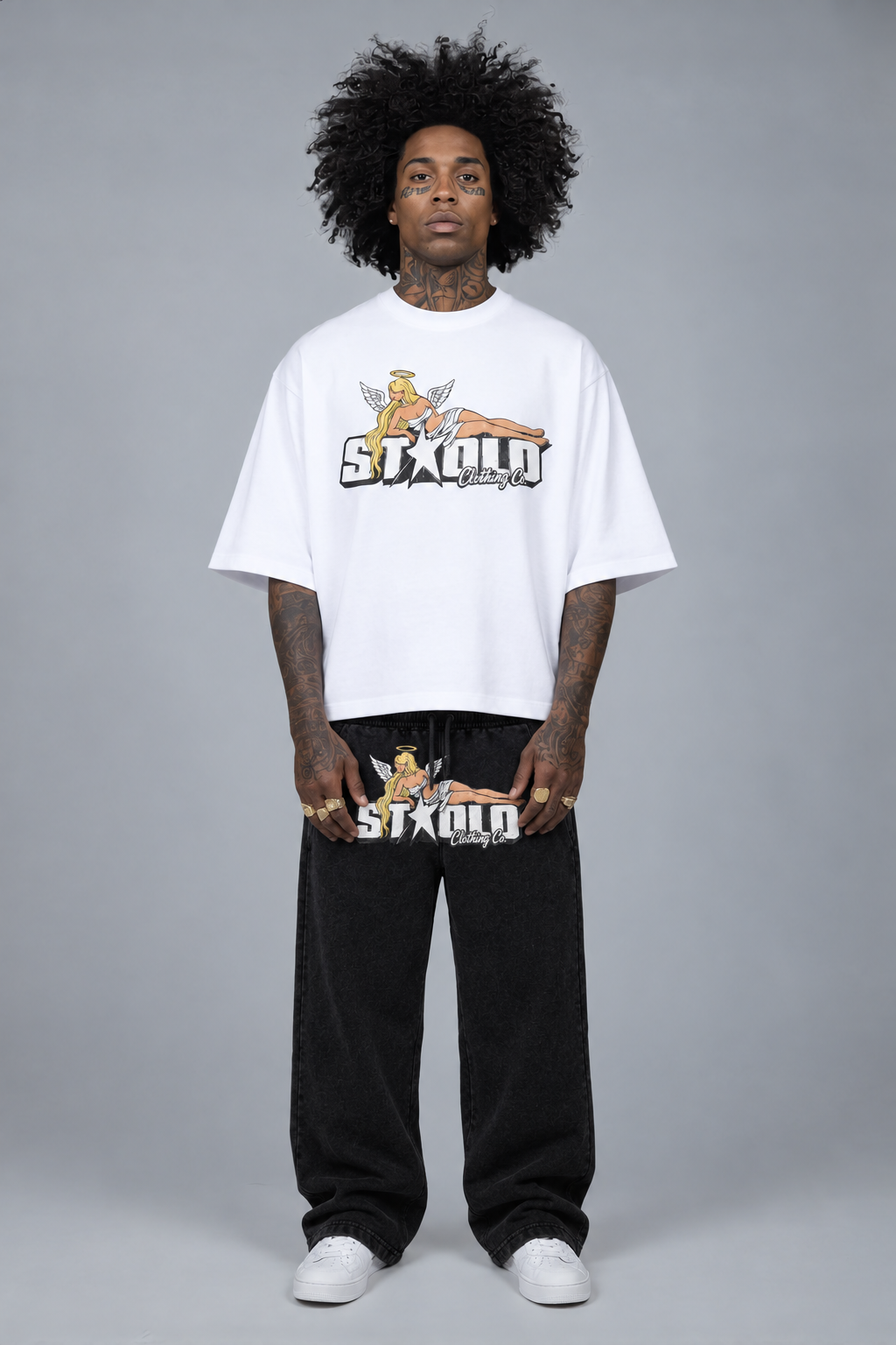Model in white graphic tee and black angel-graphic sweatpants