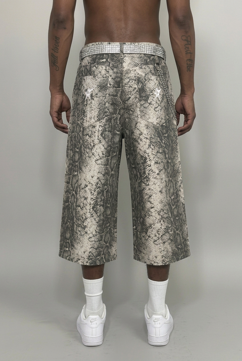Model wearing snake-print jorts with rear-pocket star logos, back view