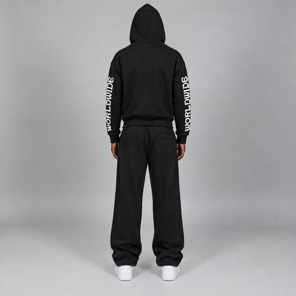 Model wearing the black STOLO hoodie and wide-leg pants, back view