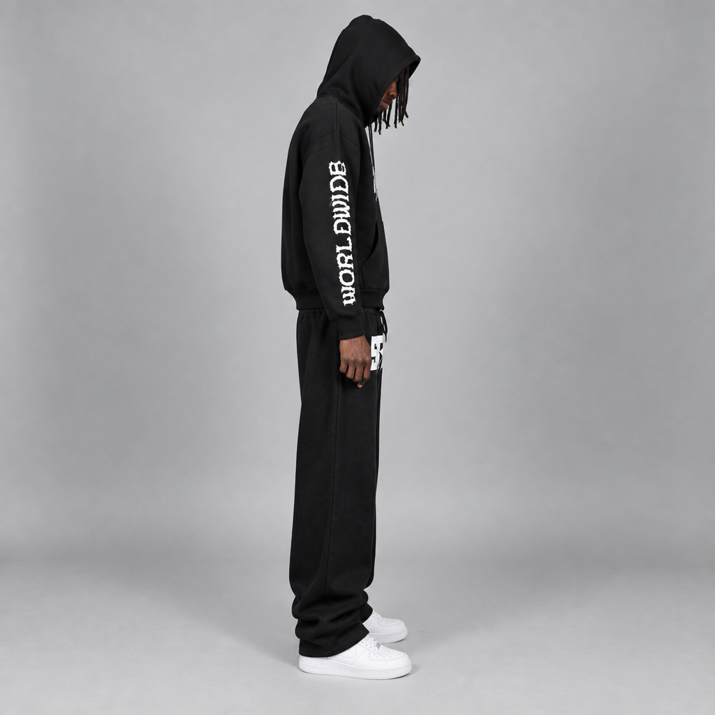Model wearing the black STOLO hoodie and wide-leg pants, side view