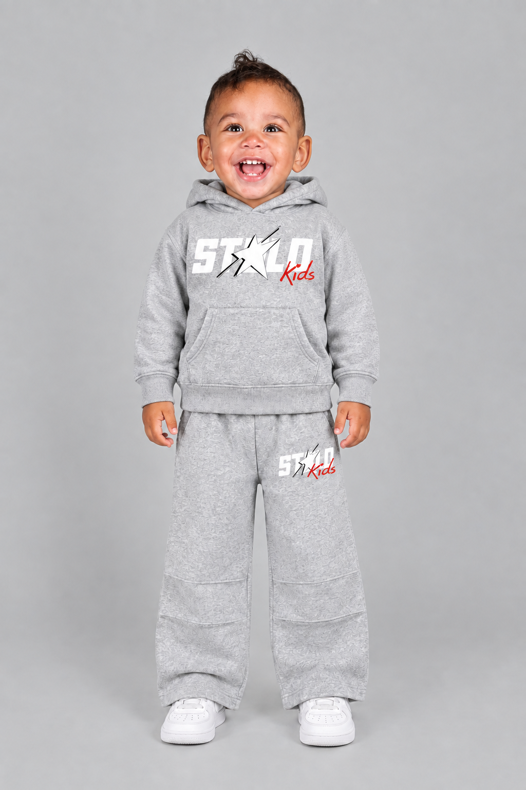 Toddler model in the grey STOLD Kids set with arms relaxed at his sides