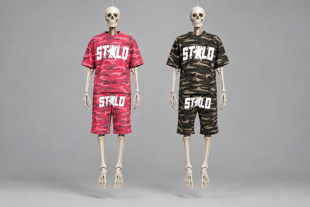 Two skeletons suspended in a grey studio wearing the pink and olive camo sets