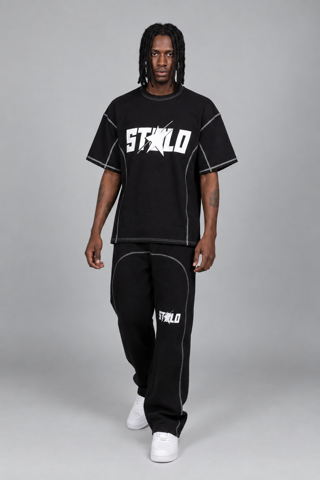 Walking pose in the black contrast-stitch STOLO set