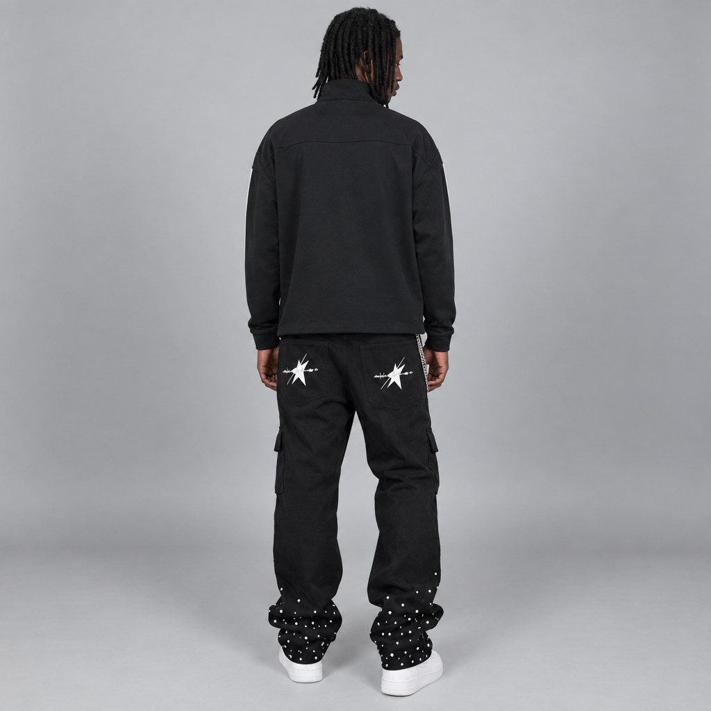 Your model in the black quarter-zip and rhinestone pants, back view