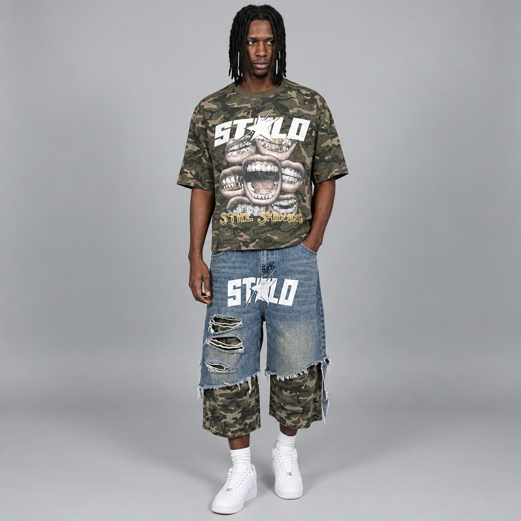 Your model in the camo Still Shining tee and distressed denim-camo shorts