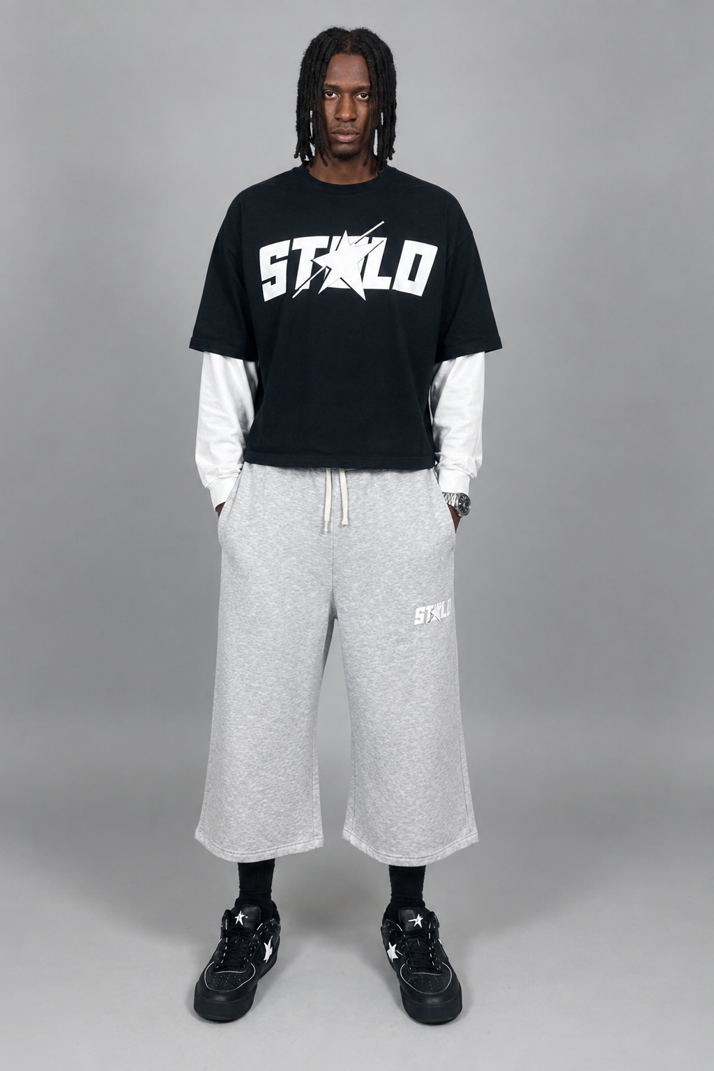 Your model in the layered STOLO tee and gray three-quarter shorts