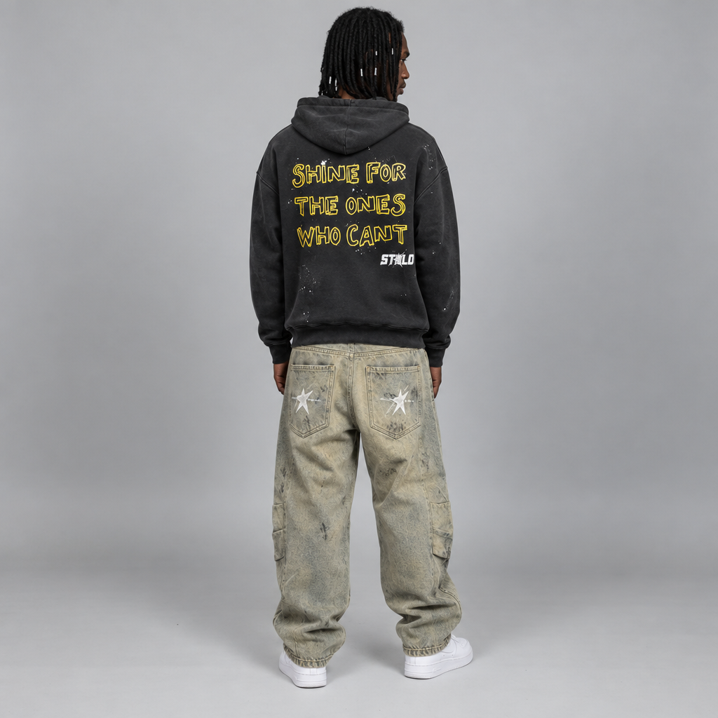 Your model in the Still Shining hoodie and beige jeans, back view